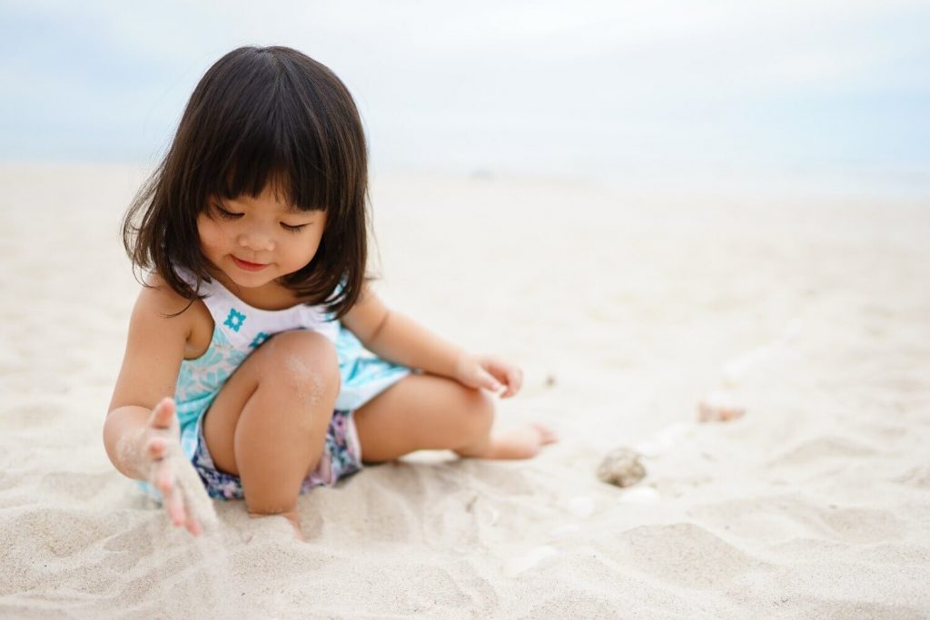 budak perempuan bermain di pantai untuk perkembangan