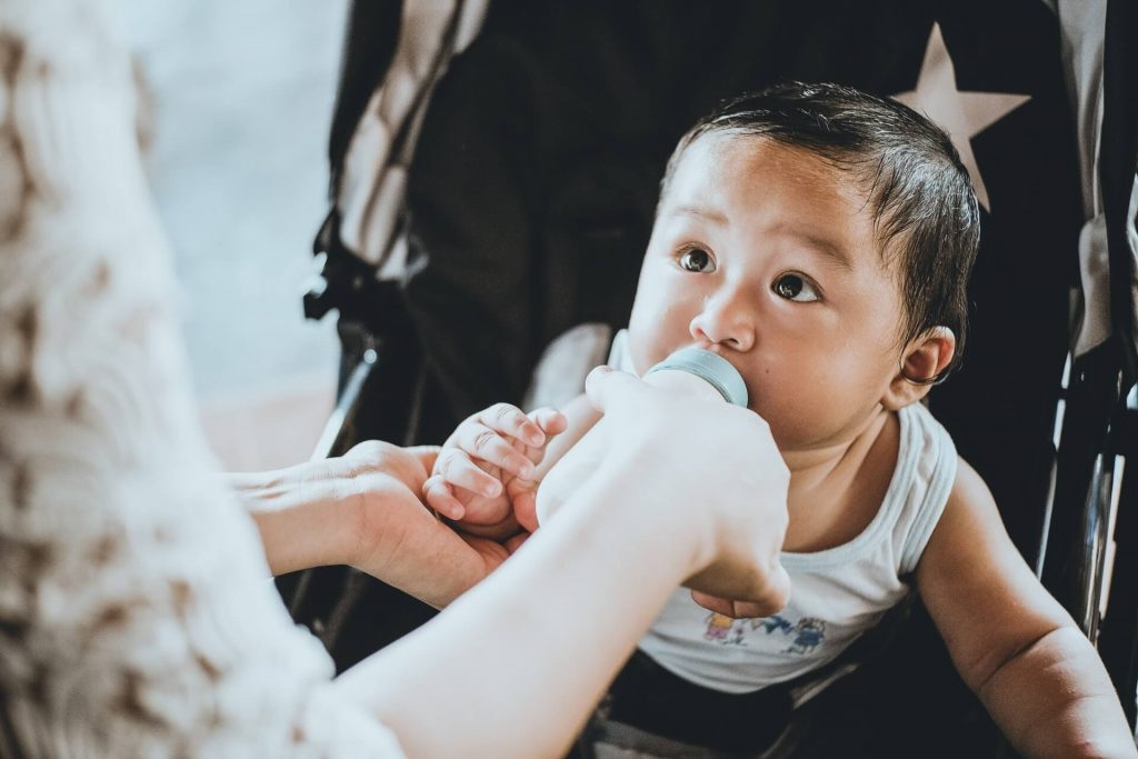 ibu suapkan susu pada anak kecil 