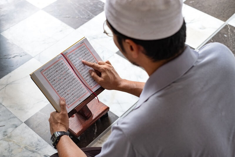 lelaki membaca al-quran dan mengamalkan doa selepas mengaji