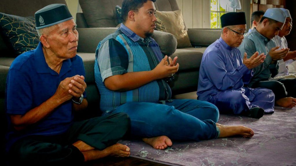 sekumpulan lelaki membaca doa majlis kesyukuran