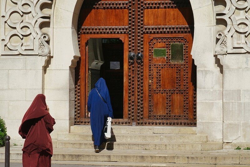 perempuan berjalan dan membaca doa masuk masjid
