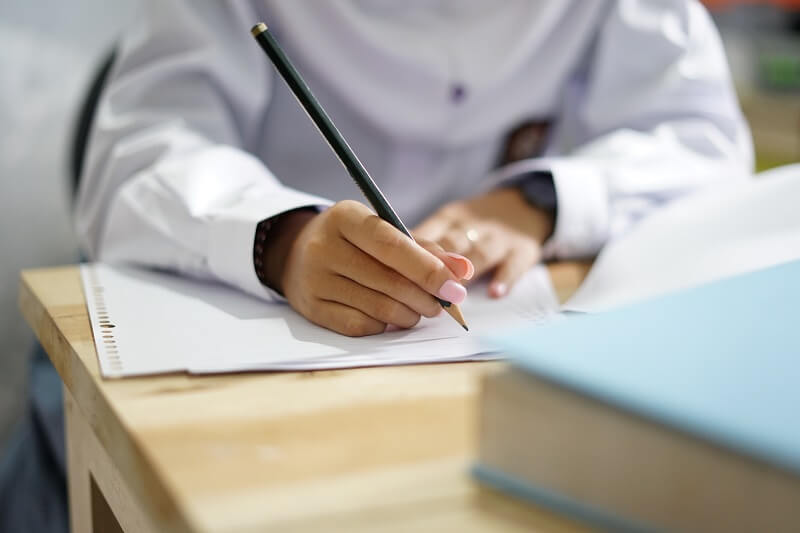 kanak-kanak perempuan menulis dan membaca doa sebelum belajar