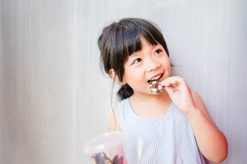 budak perempuan makan snek berkhasiat untuk kanak-kanak