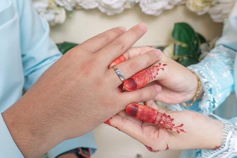 pengantin perempuan menyarungkan cincin ke pengantin lelaki selepas mengamalkan doa jodoh