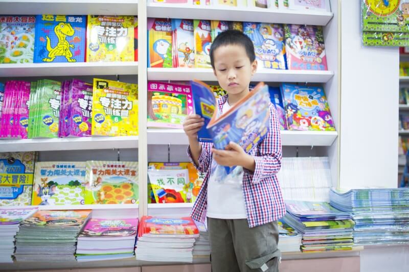 kanak-kanak lelaki membaca buku bahasa cina dan budaya Cina