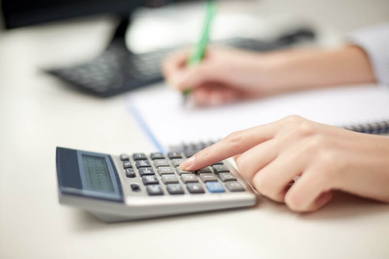wanita sedang menggunakan kalkulator dan mengira hidden cost sekolah anak