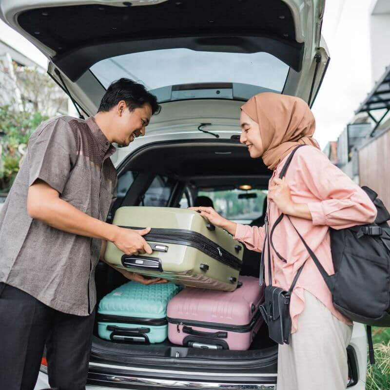 suami isteri memasukkan beg ke dalam kereta dan membaca doa perjalanan jauh