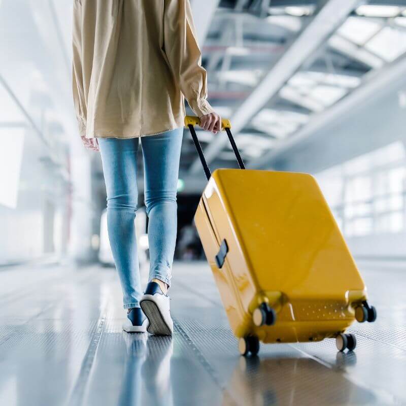 wanita menarik luggage dan membaca doa perjalanan jauh apabila tiba di destinasi