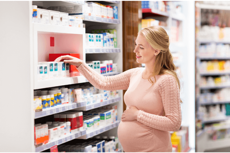 wanita hamil melihat ubat-ubatan di farmasi