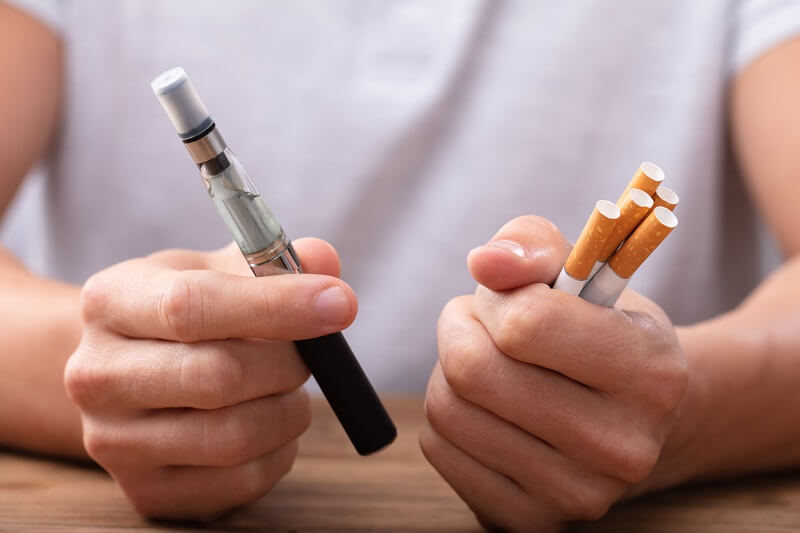 lelaki memegang rokok dan EVALI atau vape