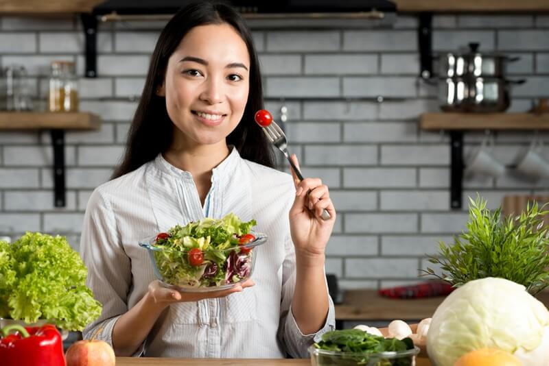 wanita makan salad