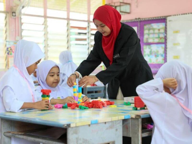 co-teaching - guru sedang mengajar murid perempuan