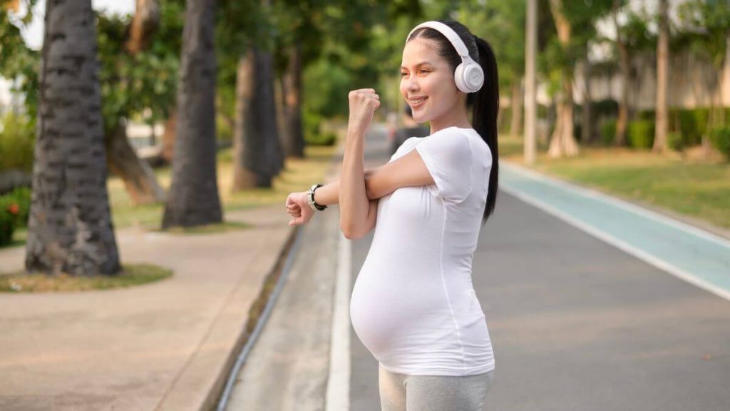 wanita mengandung bersenam di taman